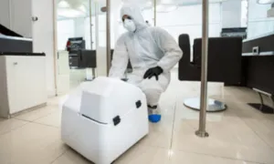operatore con dispositivi di sicurezza provvede alla sanificazione di un ufficio
