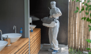 operatore con dispositivi di sicurezza provvede alla sanificazione di un bagno